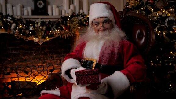 笑盈盈的圣诞老人在喜庆的红盒子里送礼物圣诞寒假