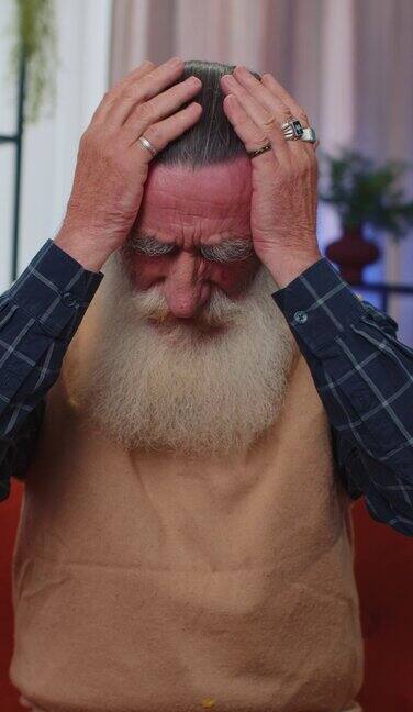 不高兴的老人揉太阳穴治疗头痛问题患有偏头痛压力大
