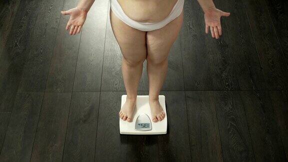 胖女士在磅秤上测量体重生气的结果节食失败