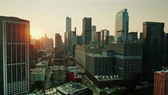 无人机飞过芝加哥河太阳在市中心建筑后升起