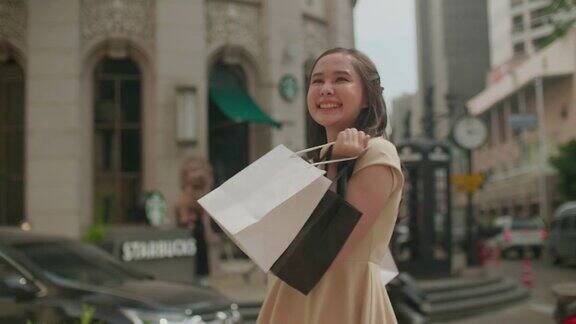 一个年轻的亚洲女人在商店里提着购物袋