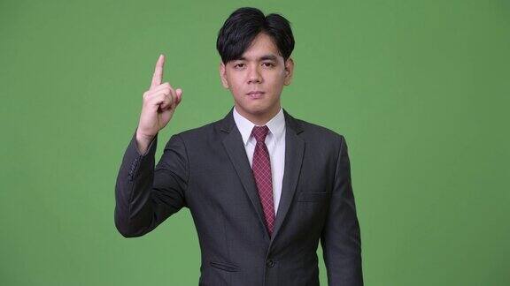 年轻英俊的亚洲商人竖起手指