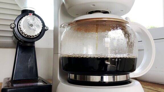 手拿一杯滴漏咖啡机放在一起煮咖啡