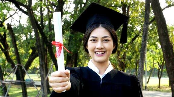 年轻的亚洲女学生戴着毕业帽和礼服花园背景女性与毕业概念