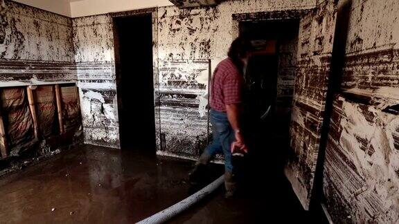 洪水地下室的人在泥浆中穿过房间
