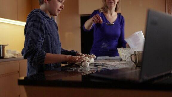 母亲和儿子在厨房包饺子