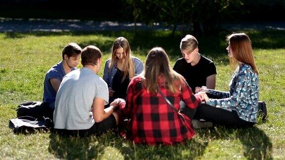 年轻的基督徒们围成一圈坐着祈祷