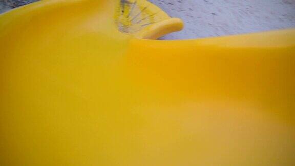 黄色的滑梯顺着白色的沙滩滑下去