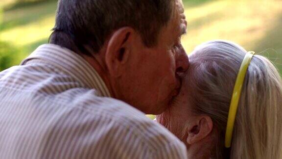 一个祖父亲吻他快乐的妻子的特写