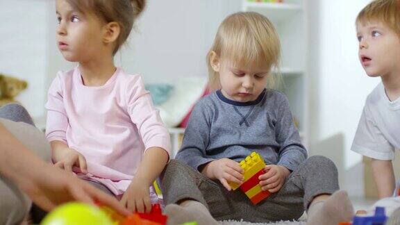 幼儿园里玩彩色砖块的可爱小男孩