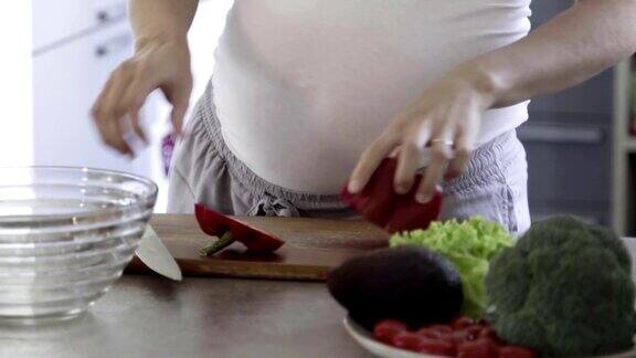 孕妇在桌上切甜椒的剪影