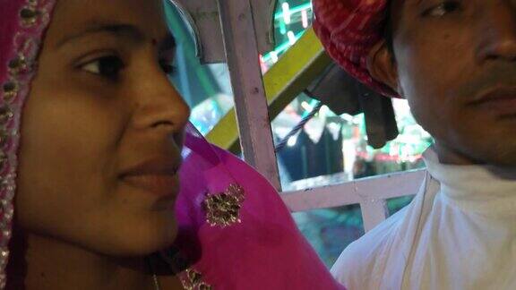 在印度拉贾斯坦邦的一场狂欢节上一对印度夫妇穿着传统服装在摩天轮上游玩