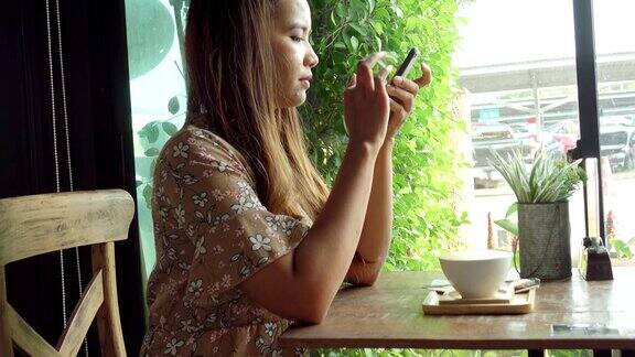 亚洲女性在咖啡馆使用智能手机