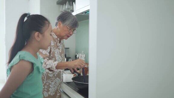 近距离的中国奶奶准备煮蒸汽中国饺子在烹饪锅在itchen