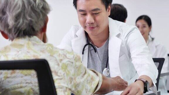 快乐组志愿者亚洲年轻男护士医生检查身体压力亚洲老年妇女以预防流行病和咨询亚洲老年妇女病人医疗、照顾、退休、志愿者、教育、医疗和药品