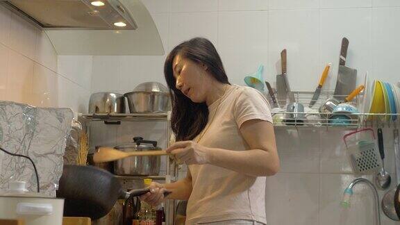 亚洲母亲在厨房做饭为家人准备食物