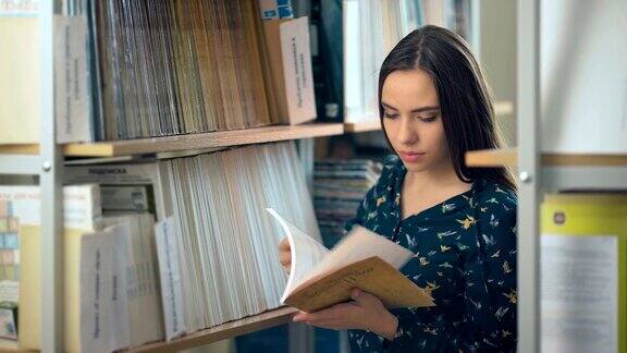 漂亮的女大学生在图书馆里找书