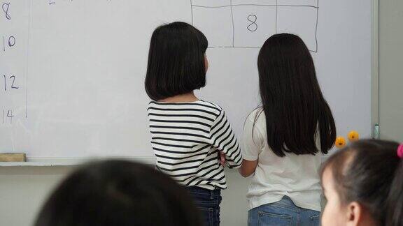 一个亚洲小女孩提出了一起思考数学答案的方法老师在学校的教室里教孩子们教育理念、经验学习和技能发展