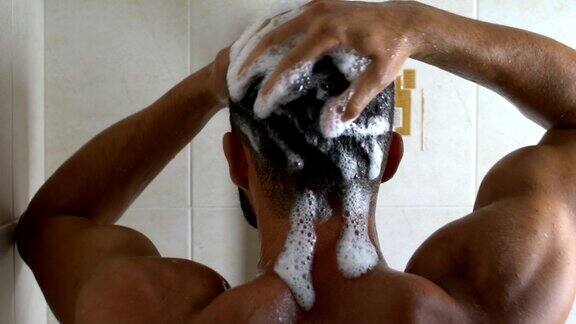 运动的男人在精疲力竭的锻炼后洗澡完美的身体洗头