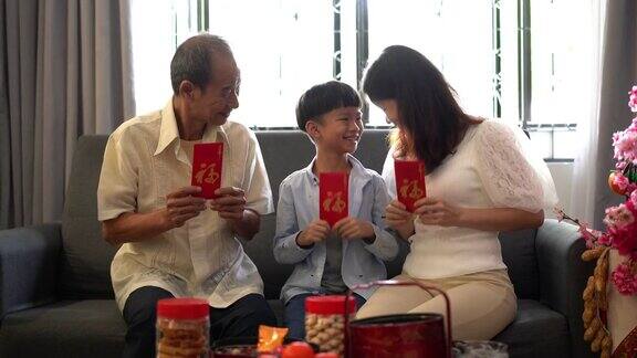 三代亚洲华人家庭在客厅里拿着红包