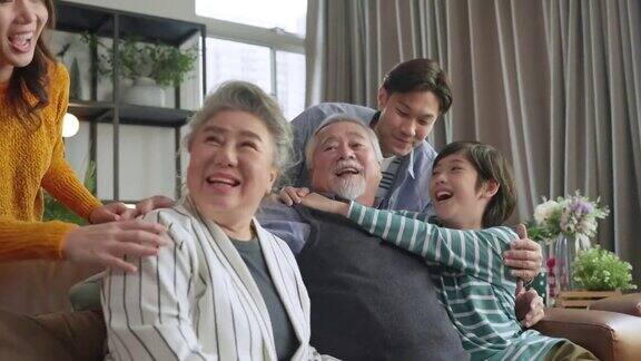 幸福的亚洲多代家庭祖父母孙子拥抱亲吻一起爱温柔照顾共度时光三代人一起玩坐在沙发上