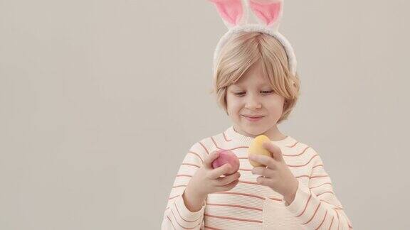 男孩的肖像与兔子耳朵和复活节彩蛋