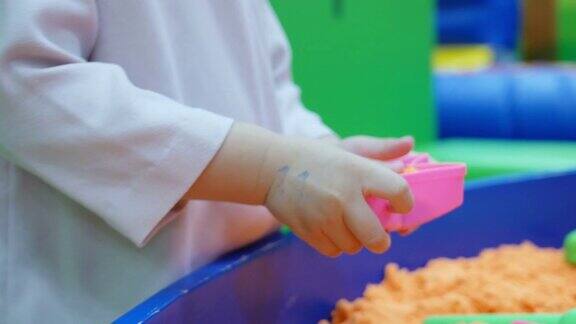 亚洲小女孩玩人造沙