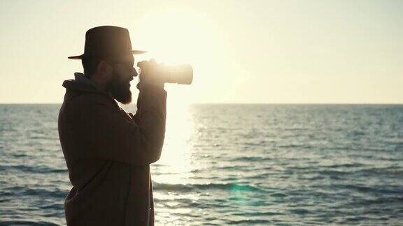 摄影师的剪影与相机在海洋表面的背景