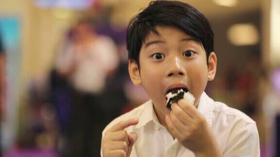 快乐的亚洲男孩吃日本食物