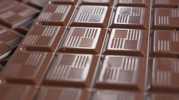 黑牛奶巧克力光泽表面和方块缓慢倾斜4K