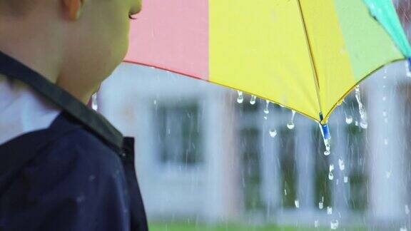 用伞接雨点的男孩