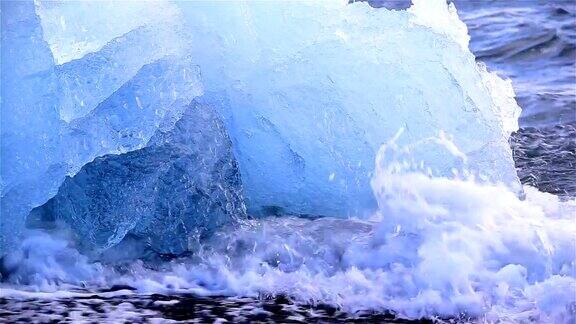 冰岛Jokulsarlon深蓝色的冰川冰海浪拍打着海岸