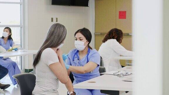护士给中年患者注射新冠肺炎疫苗