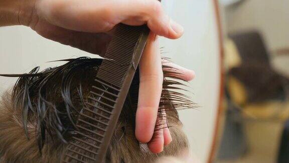 发型师在理发店里为年轻人理发