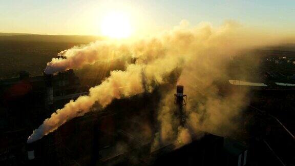 日落时重工业工厂烟囱冒烟的顶视图