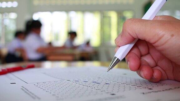 在学校或大学的考场上用铅笔将学生测试中的习题填写复写纸答题纸在校园课堂上进行文件考试教育或回到学校