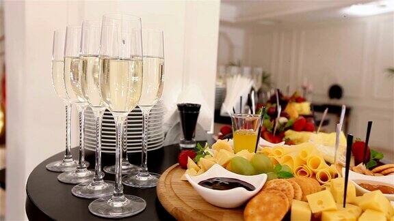 在自助餐桌上在餐厅或酒店大堂的自助餐桌上配有香槟和水果的玻璃杯镜头沿着景深浅在餐厅大堂欢迎客人