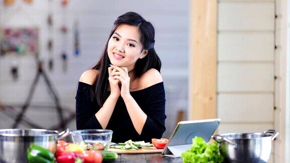 可爱的年轻亚洲女孩的肖像微笑和摆姿势看在厨房的相机