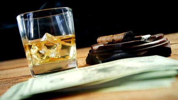 烟灰缸雪茄威士忌和美元摆在4k桌