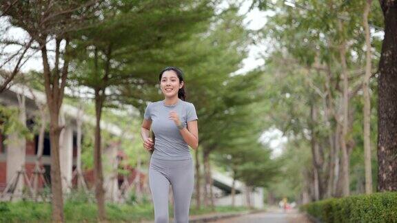 快乐苗条的女人穿着运动服在日出的城市慢跑年轻美丽的亚洲女性在运动胸罩跑步户外早上做运动健康积极的生活方式理念