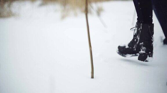 一个男人和一个女人在雪地上走过卡压在雪堆上稳定的拍摄