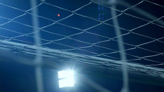 足球足球体育场馆灯光映暗天空球网在前方球飞进球门4k