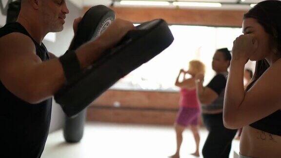女人在拳击训练与健身教练