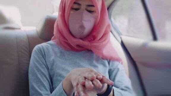 穆斯林妇女坐在车里使用洗手液