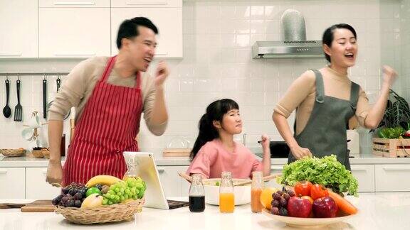 父亲、母亲和女儿试图在厨房里以同样的模式跳舞