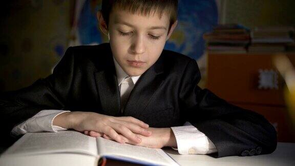 男孩穿着夹克在家做作业男孩晚上在桌子旁看书