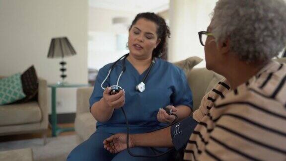 护士在家中给一位老年病人量血压