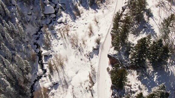 无人机拍摄的一辆卡车在山脉的雪道上行驶