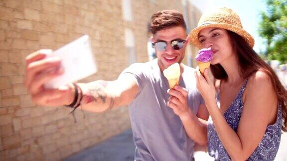 年轻的潮人情侣在夏天自拍和吃冰淇淋