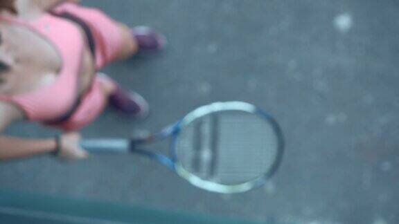 年轻漂亮的女孩打网球一个金发碧眼的长发女郎穿着粉红色的运动服从事网球训练